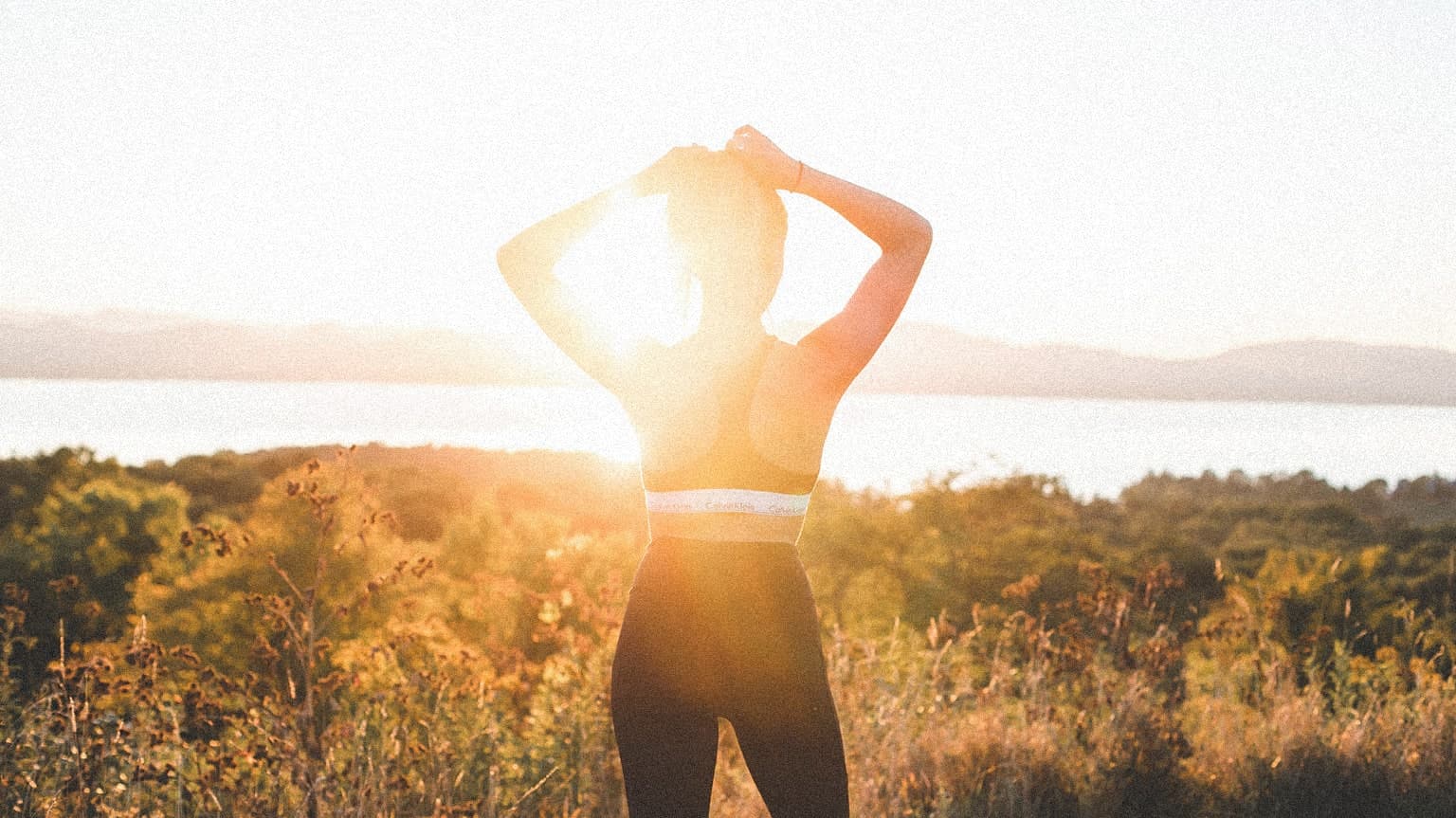 Woman fixing her hair wearing athletic attire